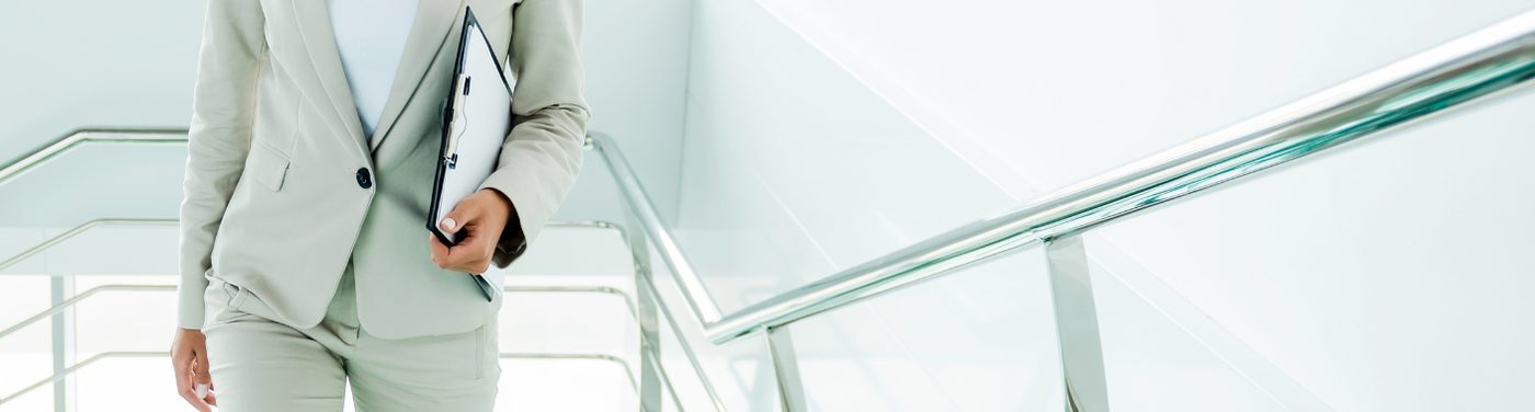 Unternehmerin mit Unterlagen auf dem Weg nach oben